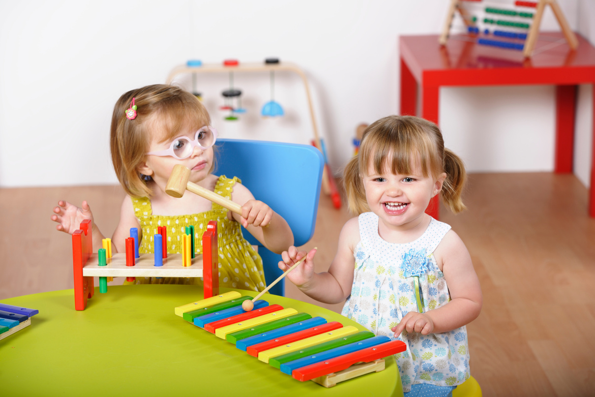 Pair Of Toddler Enjoying Music/ Playtime At Nursery